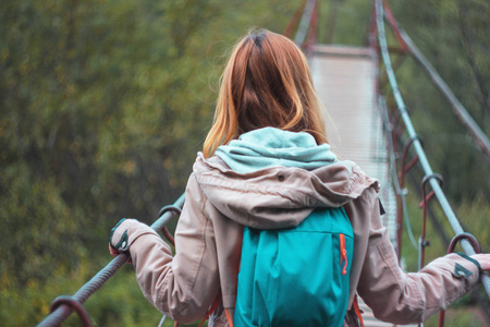 森林吊桥红色长发女孩旅行者