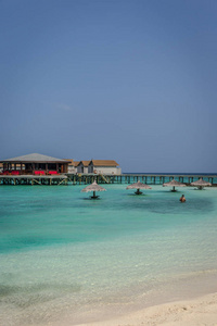 一个美丽的海湾在马尔代夫的一个大度假胜地, 绿色清澈的水与棕榈树和蓝天