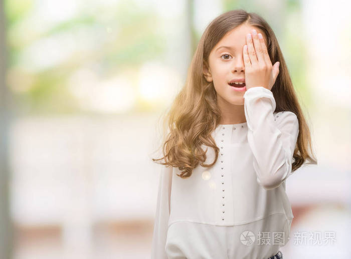 黑肤色的西班牙女孩用手捂着一只眼睛, 脸上充满自信的笑容和惊喜的