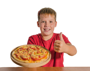 快乐少年拿着一个比萨饼在他的手上的木板