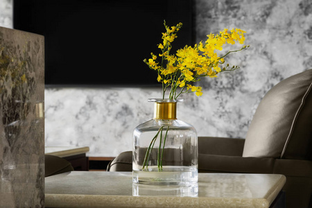 家庭内饰装饰。在一个花瓶上的黄色花朵花束在桌子上, 在灰色的墙壁背景
