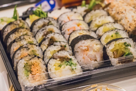 关闭了日本食品迷你 maki 寿司盘子上白木桌配芥末和酱油的肖像
