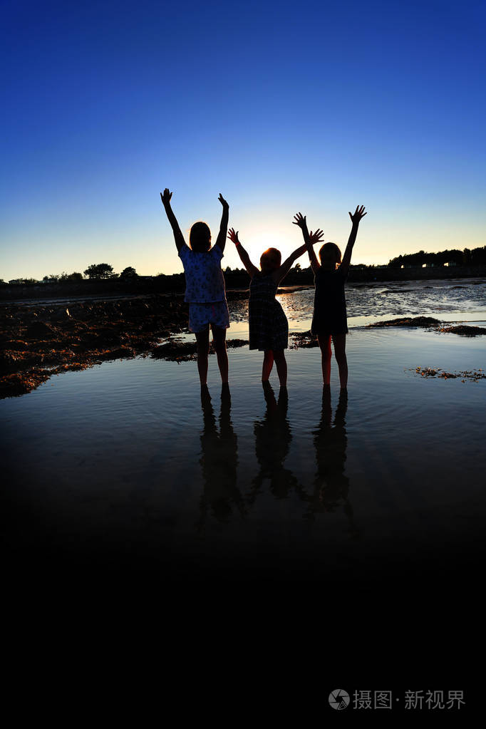 孩子们在沙滩上玩耍在水池里倒影