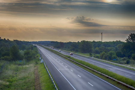 在清晨时分, 日落的道路。惊人的云彩和音调