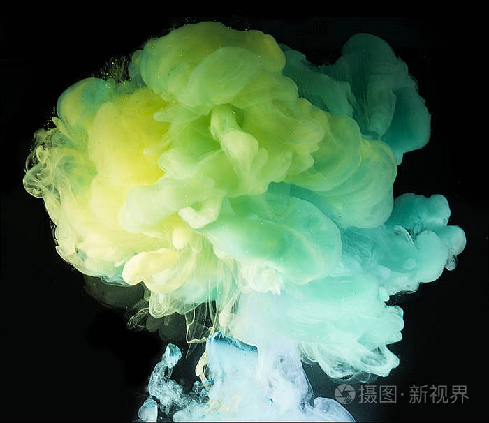 五颜六色的彩虹颜料从上面的水中混合而出.水下旋转墨水