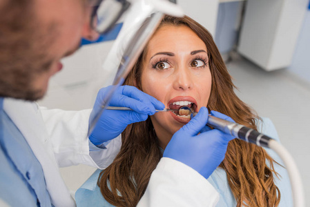 牙科医生在牙科诊所检查病人的牙齿
