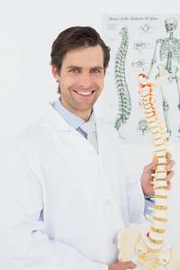微笑的男性医生与骨架模型的肖像