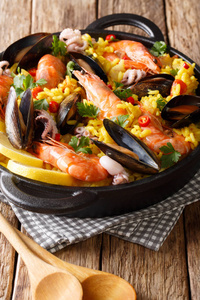 西班牙海鲜饭与虾, 贻贝, 鱼, 和婴儿章鱼特写在桌上煎锅。vertica