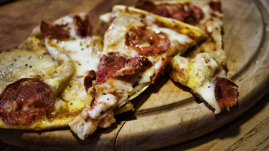 披萨。三件美味比萨。在木架上的香肠比萨