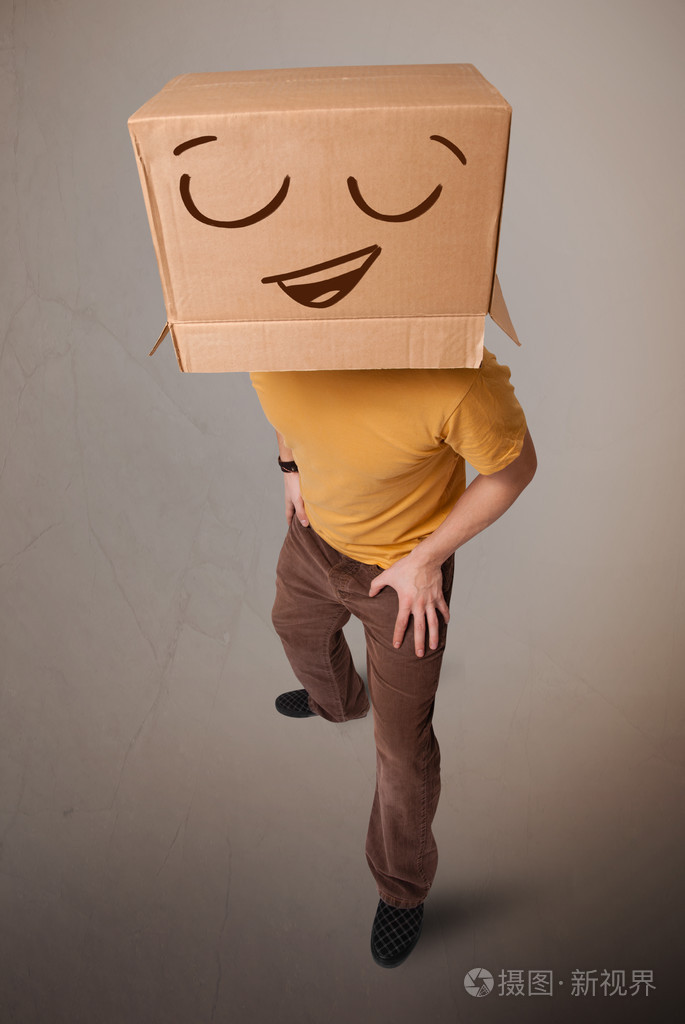 打手势用纸箱与笑脸他头上的年轻人