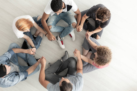 青少年在集体治疗中坐在圈子里牵手的最高视角