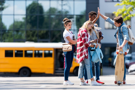 五名青少年学生在校车前停车