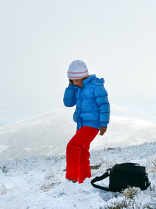 女孩说话的山冬季高原上的手机