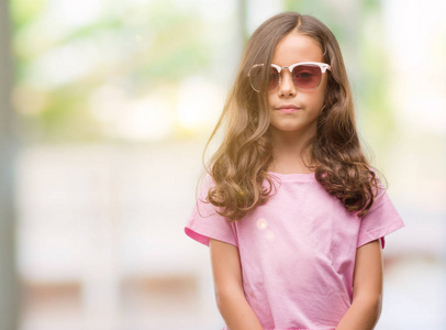 黑发西班牙裔女孩戴着太阳镜, 自信的表情对聪明的面孔认真思考