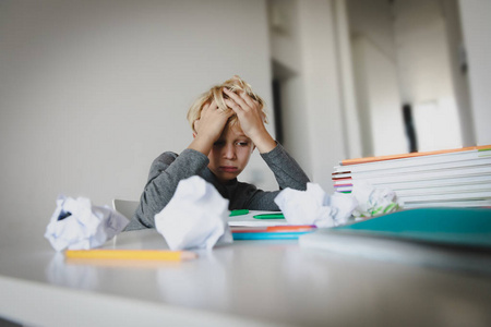 小男孩疲劳地看书, 做作业照片