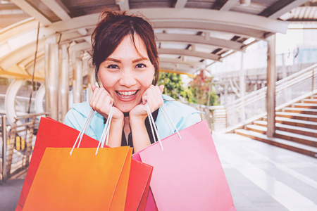 快乐的女人与购物袋享受购物。妇女购物, 生活方式概念