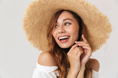 图片的内容迷人的女孩20s 戴着大草帽看着一旁愉快的微笑孤立的白色背景