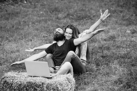 幸福的夫妇，爱上了飞行姿态和室外的笔记本电脑