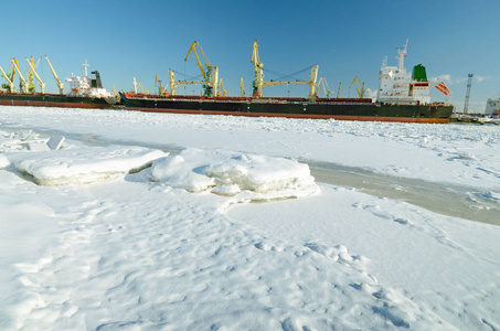 货物港口的自然景观。货物港口的自然景观。海湾结冰了装载货物的船舶