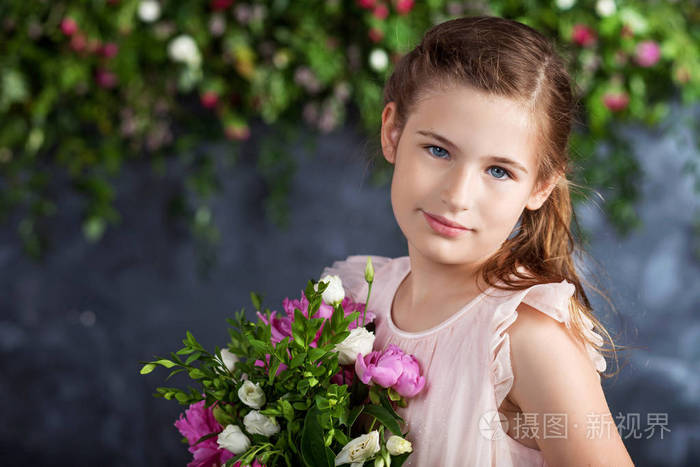 可爱的小女孩的肖像与一束花。看相机
