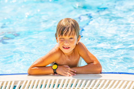 微笑可爱的男孩的肖像游泳和在游泳池的乐趣, 特写