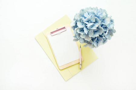 剪贴板模拟与纸空白和蓝色绣球花花束在白色背景。平躺, 顶部视图