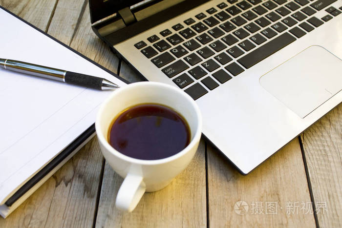 木桌上的笔记本电脑,笔记本和咖啡杯