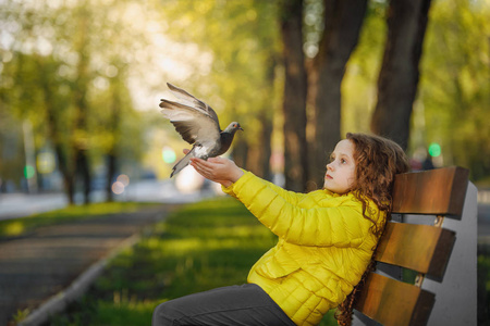 小女孩穿着黄大衣, 手里拿着鸽子.自由, 希望概念照片