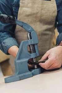 裁剪图像的男性手袋工匠与工具在工作室