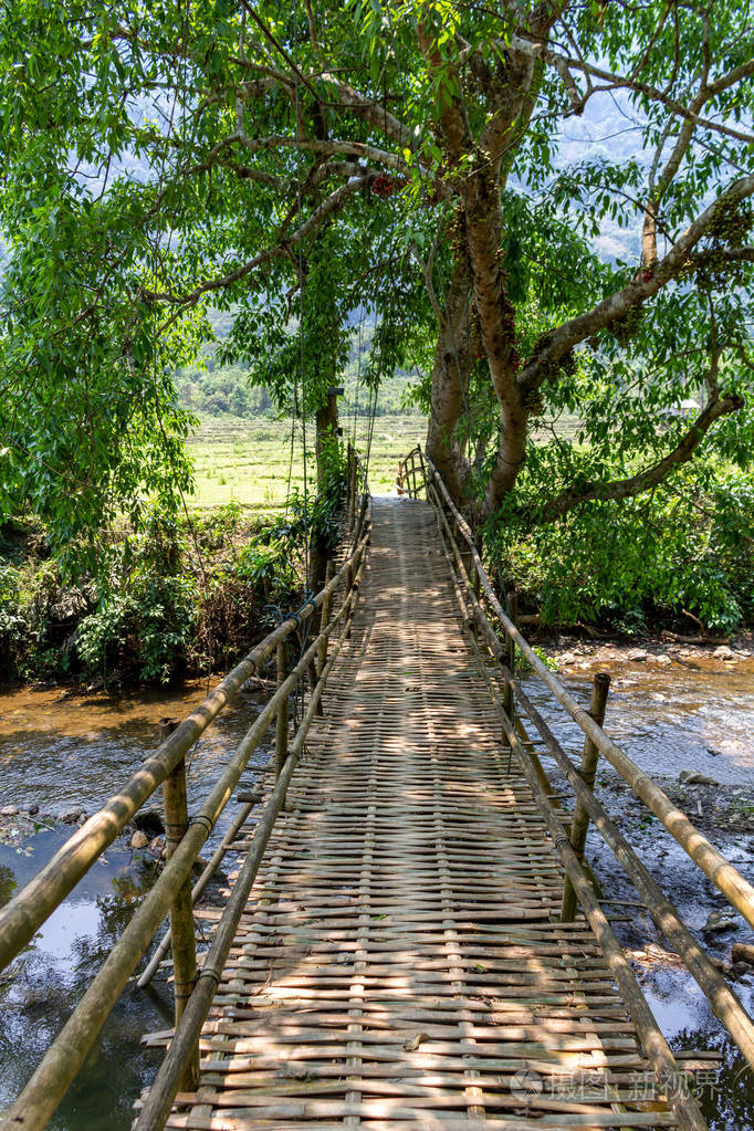孟清爱民, 老挝-2018年4月10日: 老挝绿色乡村的一条河上的木桥