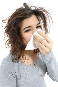 一个女人与流感和一块手帕在鼻子的特写