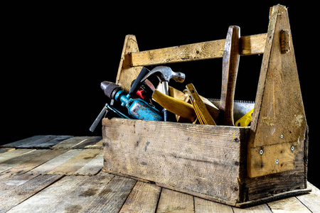 盒与配件为木匠。木工工具在一个木制车间桌子上的板条箱。深色背景