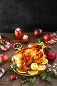 烤圣诞鸡或火鸡作为圣诞晚餐。节日装饰的木桌圣诞晚餐与烤鸡