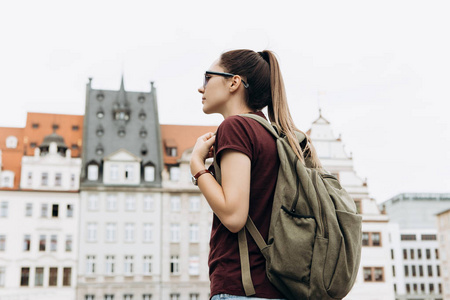 在莱比锡背包的旅游女孩欣赏美丽的建筑