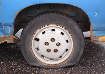 生锈的蓝色货车停泊在沥青上轮胎漏气照片