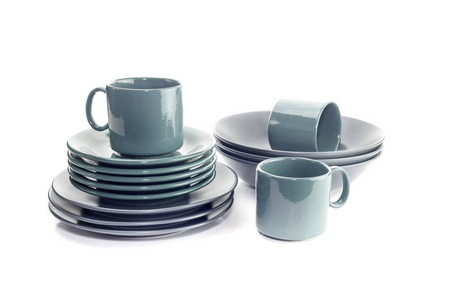 餐具。新的, 绿色的杯子, 碟子和灰色的盘子在白色背景特写