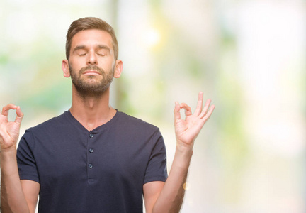 年轻英俊的男人在孤立的背景下放松和微笑闭上眼睛做冥想手势用手指。瑜伽理念