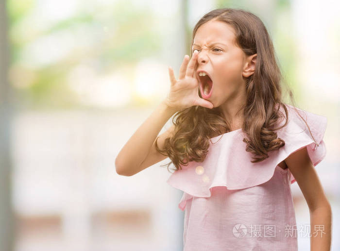 穿着粉红色礼服的黑发西班牙裔女孩大声地大叫着, 用手在嘴上尖叫。沟通理念