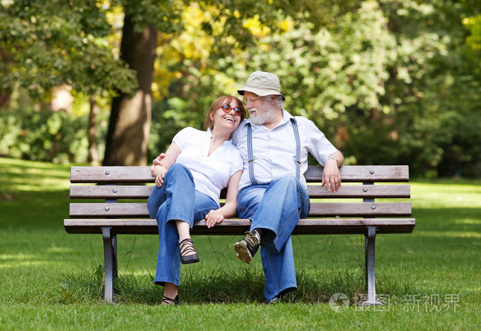 高级夫妇坐在公园的长椅上