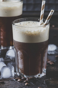 冷刨冰咖啡与冰和泡沫在棕色背景大玻璃, 选择性聚焦