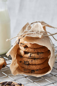 一个手工包装的巧克力饼干与巧克力薯条在烘烤格栅与牛奶瓶在背景。天然手工有机蛇健康早餐