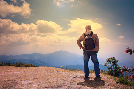人站在山顶，背包里的旅行者