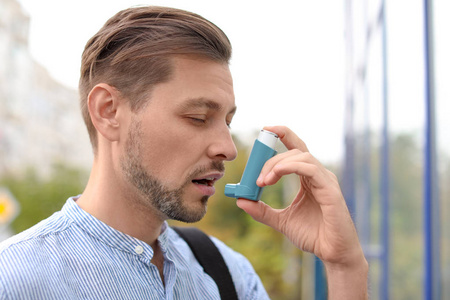 在户外使用哮喘吸入器的人。保健