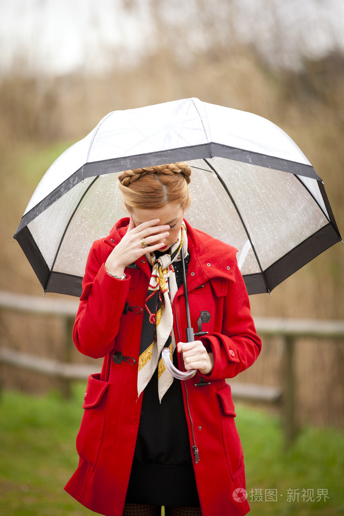 孤独的女孩在一个公园里一个下雨天用的伞