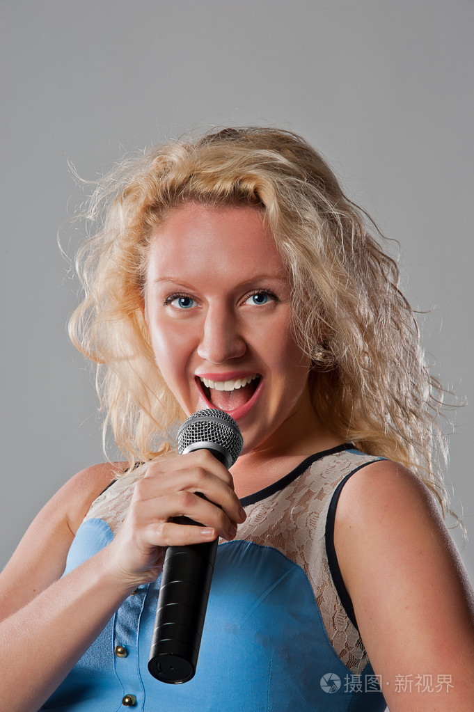 在麦克风唱歌的漂亮女人