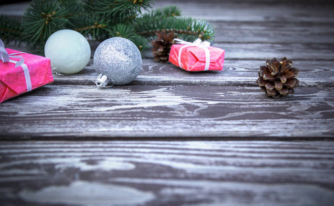 圣诞假期背景与礼品盒与冷杉分支, 松树锥体, 圣诞球在木桌上