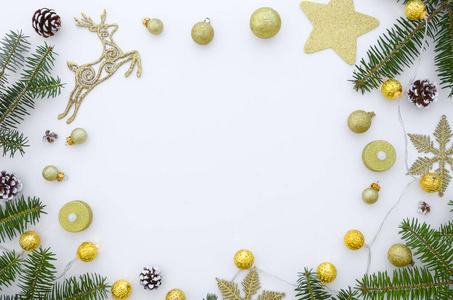圣诞节框架由金色圣诞装饰品, 松树树枝, 松树锥白色背景。平躺, 顶部视图, 复制空间模拟