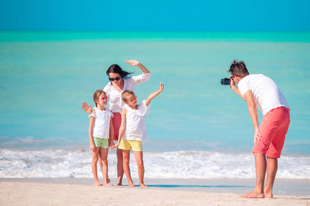 四家庭在海滩度假时拍一张自拍照片。家庭海滩度假酒店