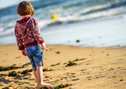 一个年轻可爱的孩子站在海洋前