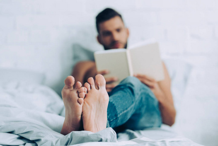 男人在家里卧室看书的选择性焦点